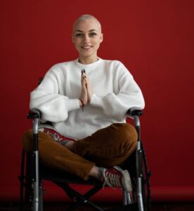 cheerful woman practicing yoga with praying hands in wheelchair
